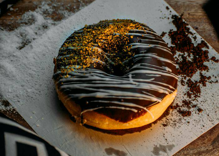 A donut dusted with chocolate and biscuit crumb.